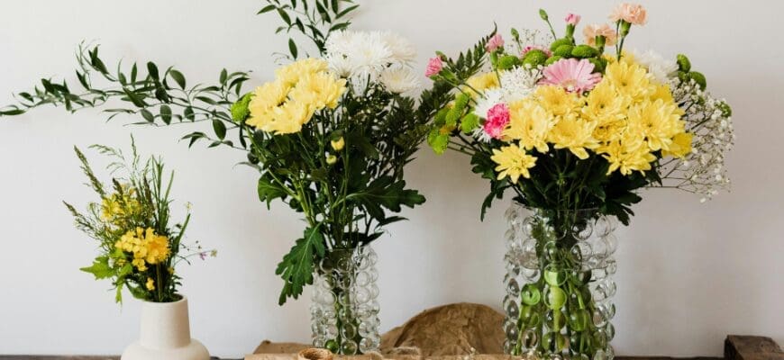 Table with 3 Vases of Flowers and Bouquet Making Supplies: Paper, Twine, Cutters, and Flower Pieces